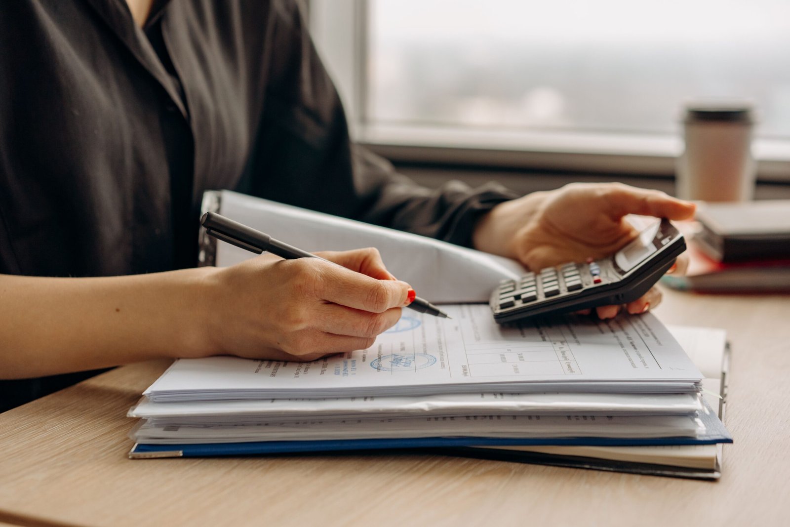 TIN vs TAE: persona calculando ambos con una calculadora y documentos de la hipoteca